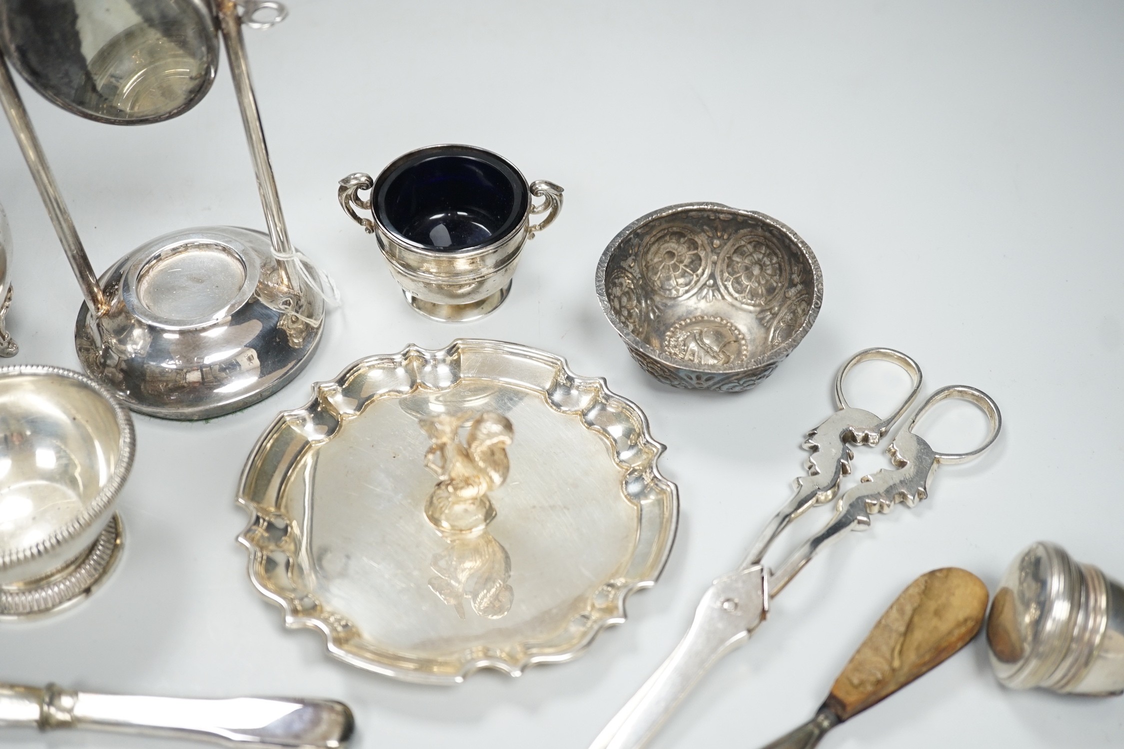 A 1920's silver mounted manicure stand with mirror and three associated implements, a small silver two handled salt, modern silver bowl, continental repousse white metal bowl, boxed modern silver letter opener and four p